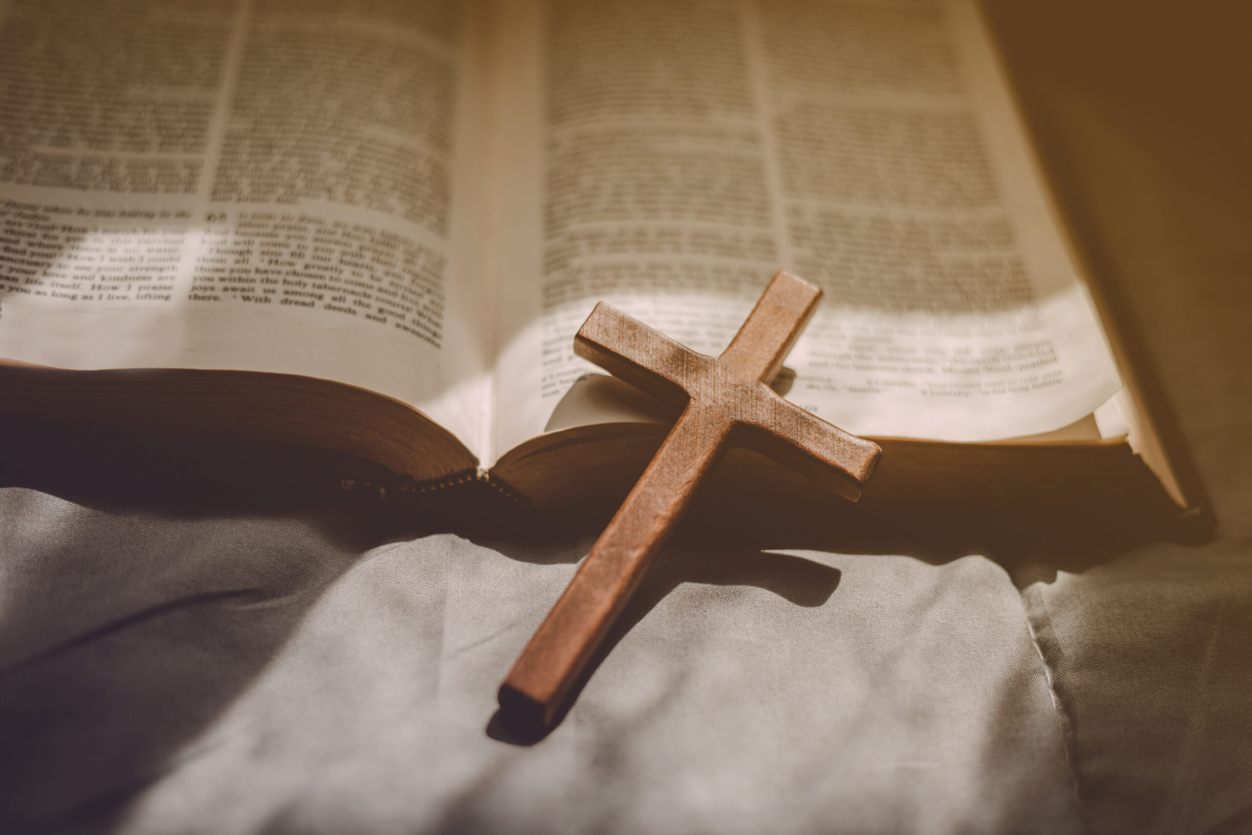 Crucifixion of Jesus christ ,cross with the holy bible at sunlight